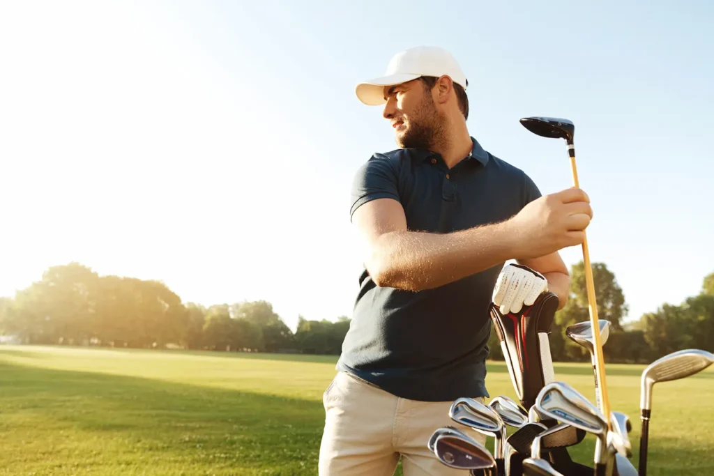 a man pulls a club from his golf bag