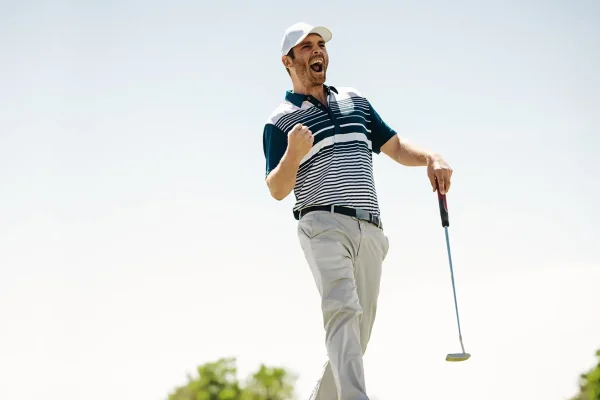 a man celebrates after a great shot on the golf course