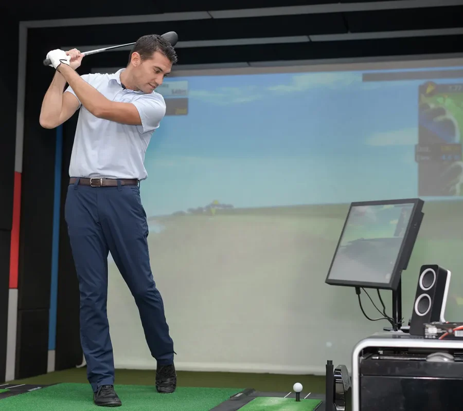 cameras record a man's swing in this indoor golf simulator